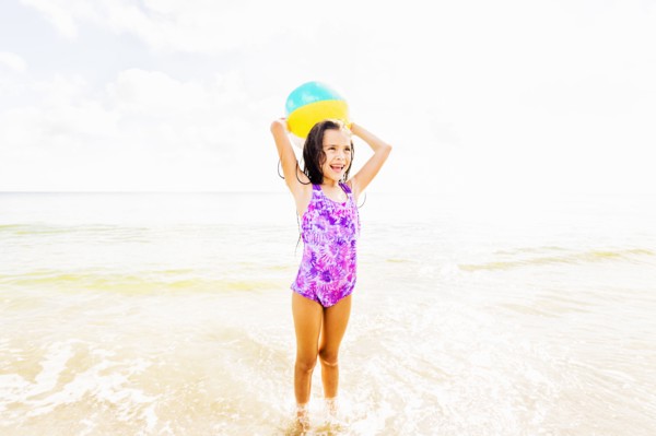 Girl (6-7) playing with ball on beach