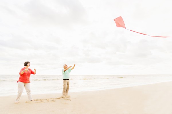 Couple flying kite together on beach