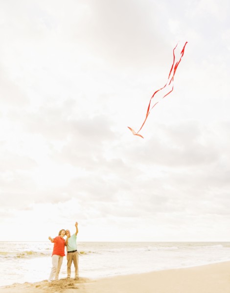 Couple flying kite together on beach