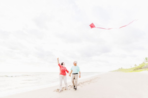 Couple flying kite together on beach