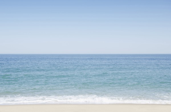 Seascape with surf on sandy beach