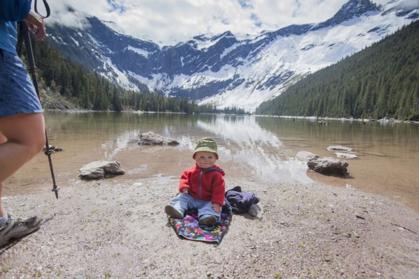 Boy (4-5) sitting on lakeshore