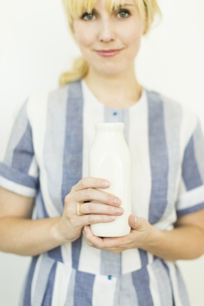 Studio shot of woman holding milk bottle