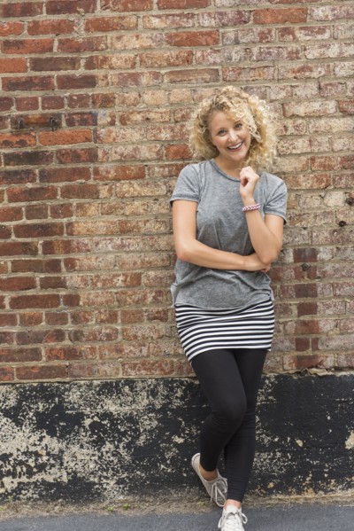 Portrait of young woman in front of brick wall.