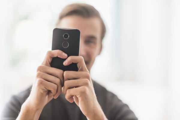 Close-up of man using mobile phone.