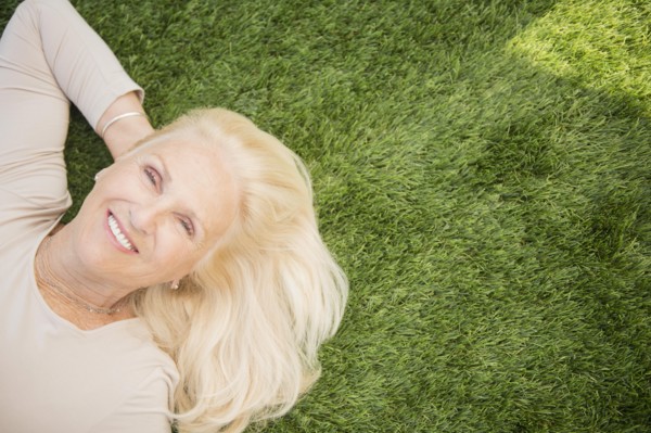 Senior woman lying on grass