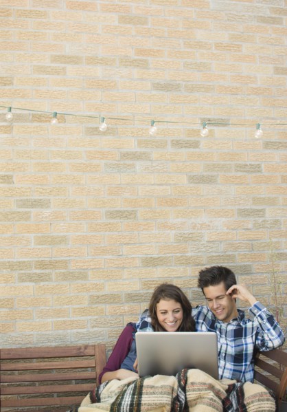 Young couple using laptop on roof