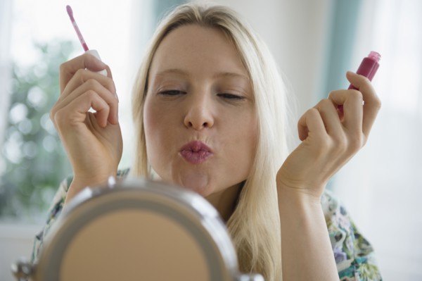 Woman applying lipgloss