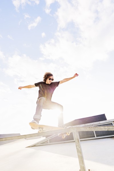 Man jumping on skateboard in skatepark