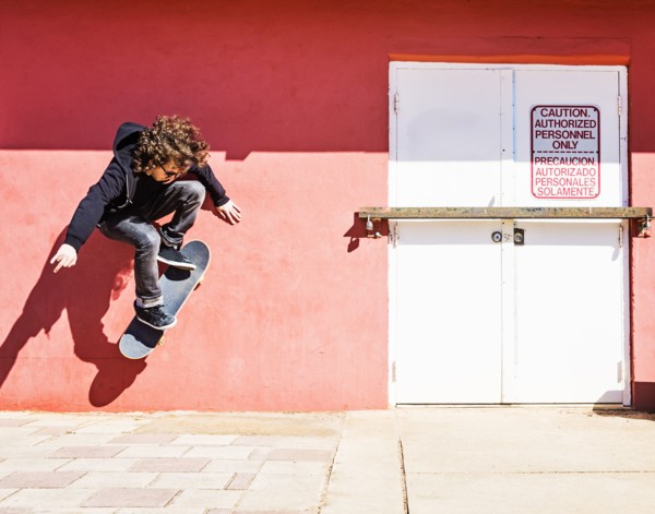Man skating near red wall