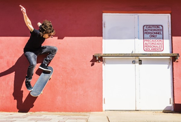 Man skating near red wall