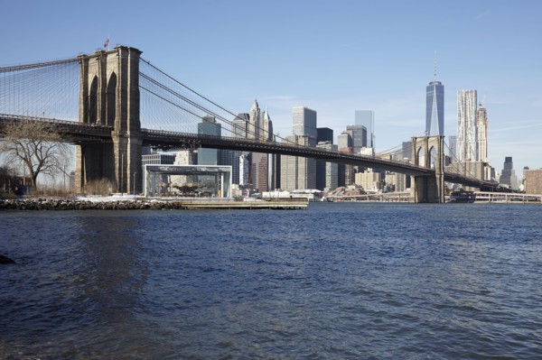 View of waterfront cityscape with suspension bridge
