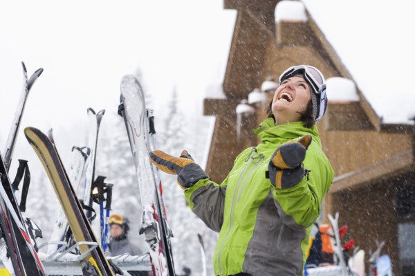 Woman wearing ski googles with hands raised