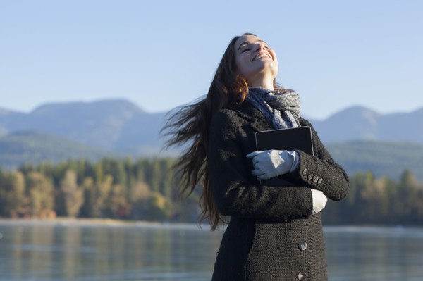 Woman with tablet by lake