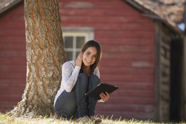 Portrait of woman sitting outdoors with tablet