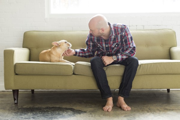 Man sitting on sofa stroking pug