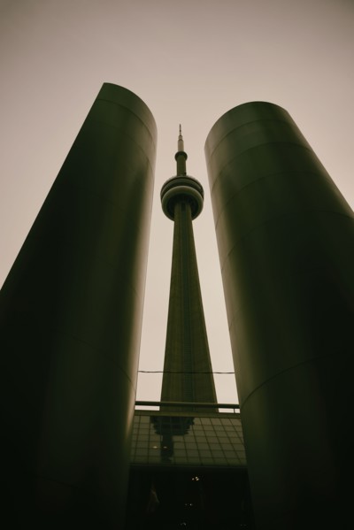Low angle, symmetrical view of built structure and communications tower, tinted image