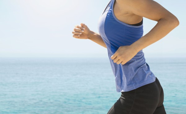 Young woman exercising by sea.
