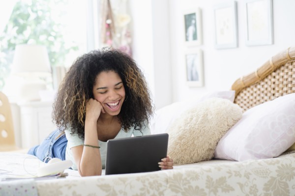 Teenage girl (16-17) using tablet pc in bedroom.