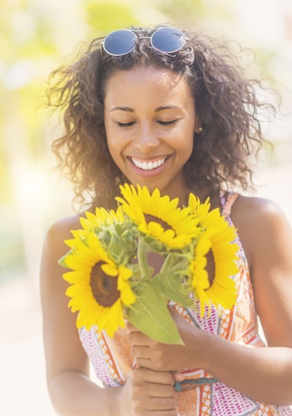 Portrait of smiling woman with sunflowers