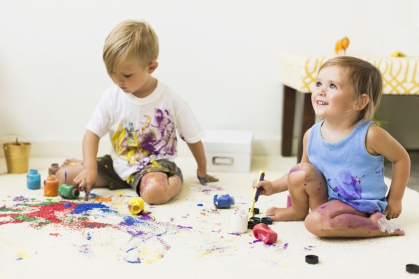 Children (2-3) painting on carpet