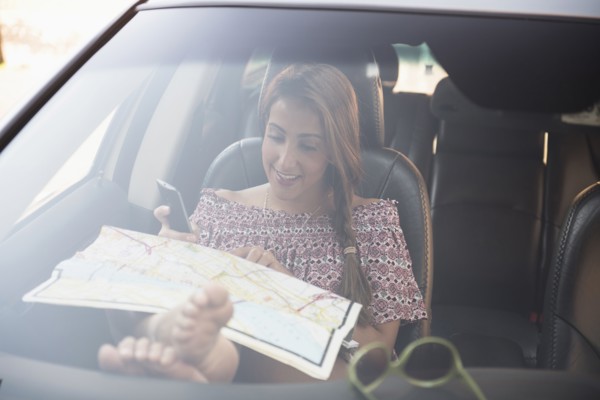 woman sitting in car and looking at map.