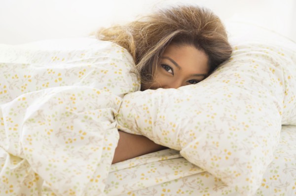 Young woman lying in bed.