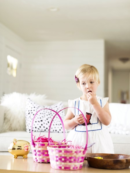 Girl (2-3) eating candy in living room