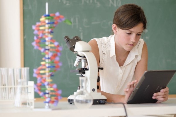Girl (10-11) using tablet pc in classroom.