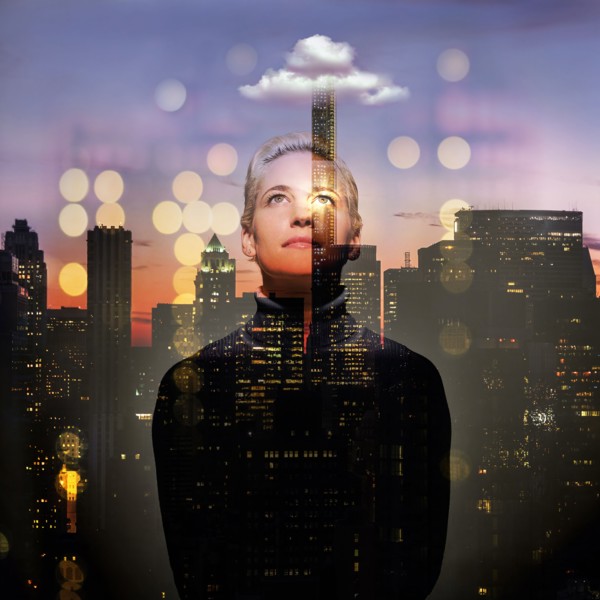 Young woman looking up at night. USA, New York, New York City.