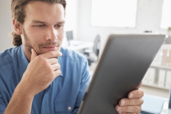Mid-adult man using tablet pc.