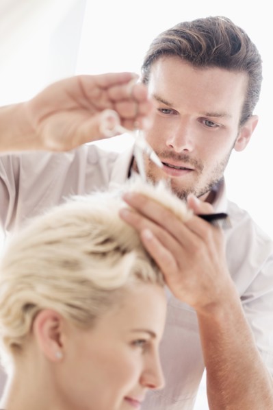 Hairdresser cutting woman's hair.