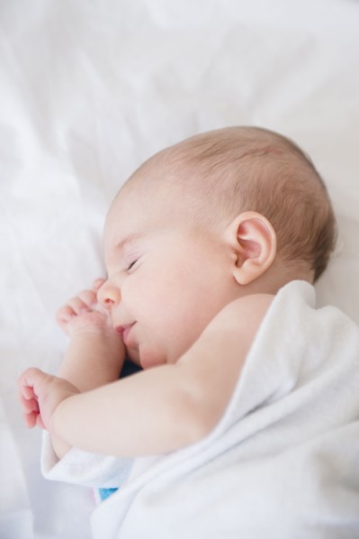Baby girl (2-5 months) sleeping on bed