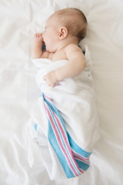 Baby girl (2-5 months) sleeping on bed