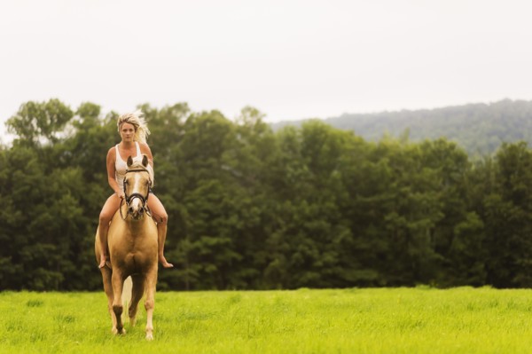 Woman horseback riding in countryside