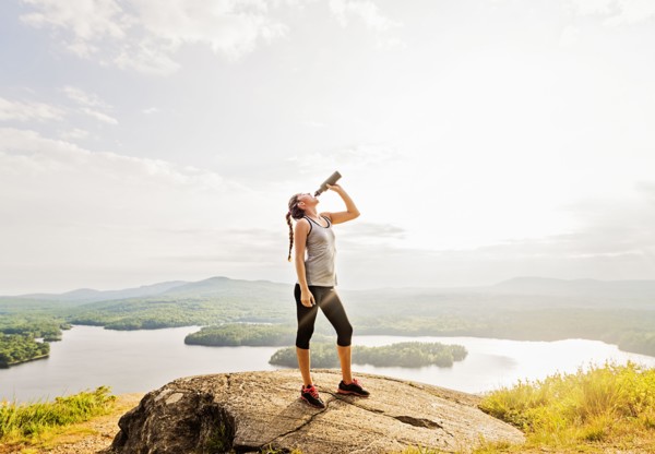 Woman drinking water after doing exercises