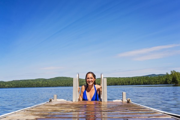 Young woman coming out of water on jetty