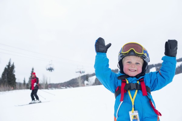 Smiley little boy (5) wearing ski suit in mountains