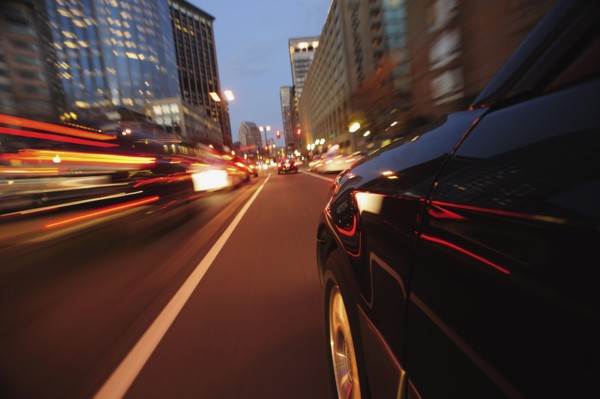 Car driving through city at dusk