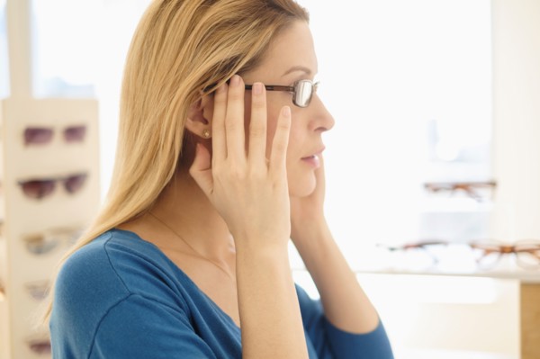 Woman trying on eyeglasses in store.