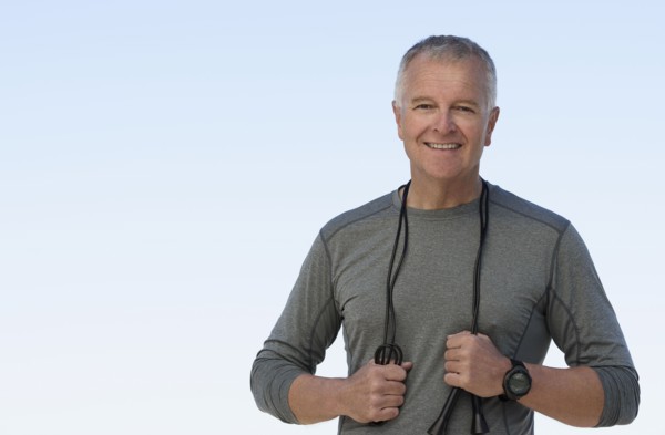 Man with jump rope against clear sky.