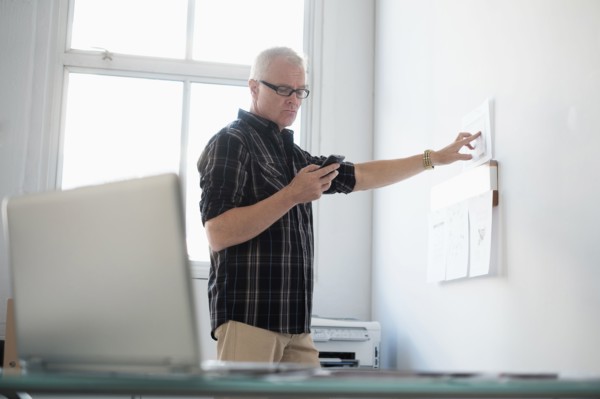 Man in office using smartphone.