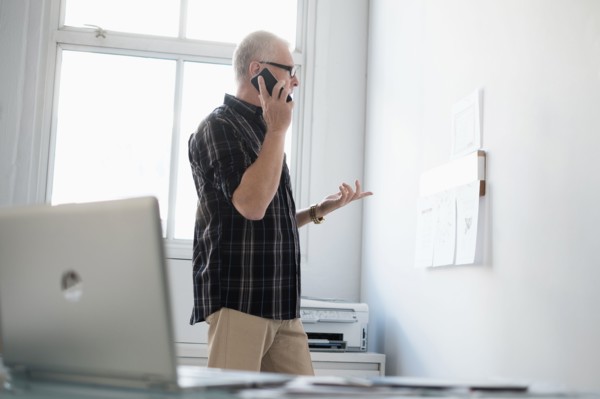 Man in office using smartphone.
