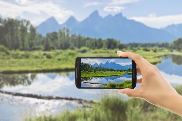 Hand photographing lake. Grand Tetons, Grand Teton National Park, Wyoming, USA.