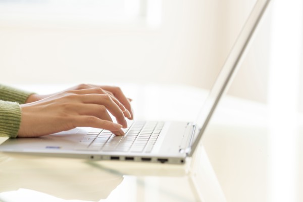 Hands typing on laptop keyboard.