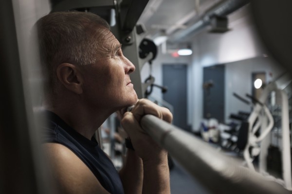 Man in health club doing chin-ups.