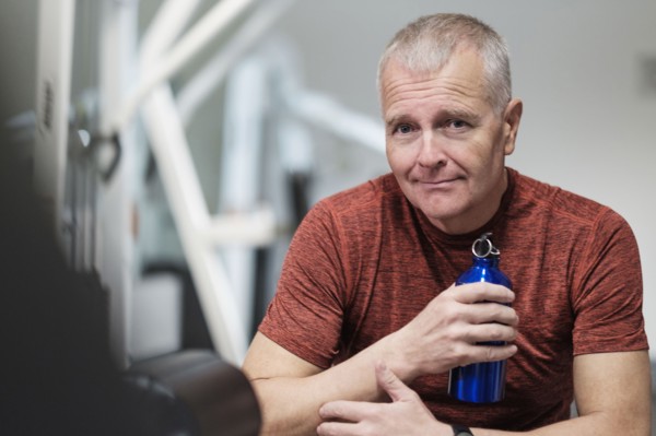 Portrait of man in health club with water bottle.