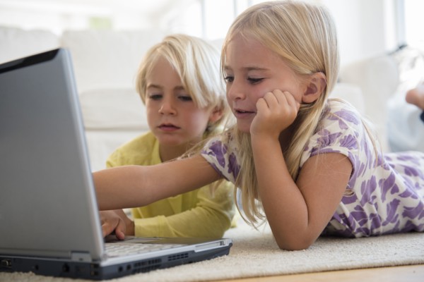Boy (4-5) and girl (6-7) using laptop