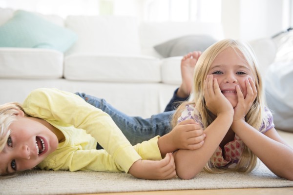Boy (4-5) and girl (6-7) lying on floor