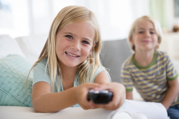 Boy (4-5) and girl (6-7) sitting on sofa